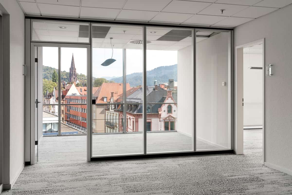 Büroraum mit Glastrennwand und Blick auf das Freiburger Münster
