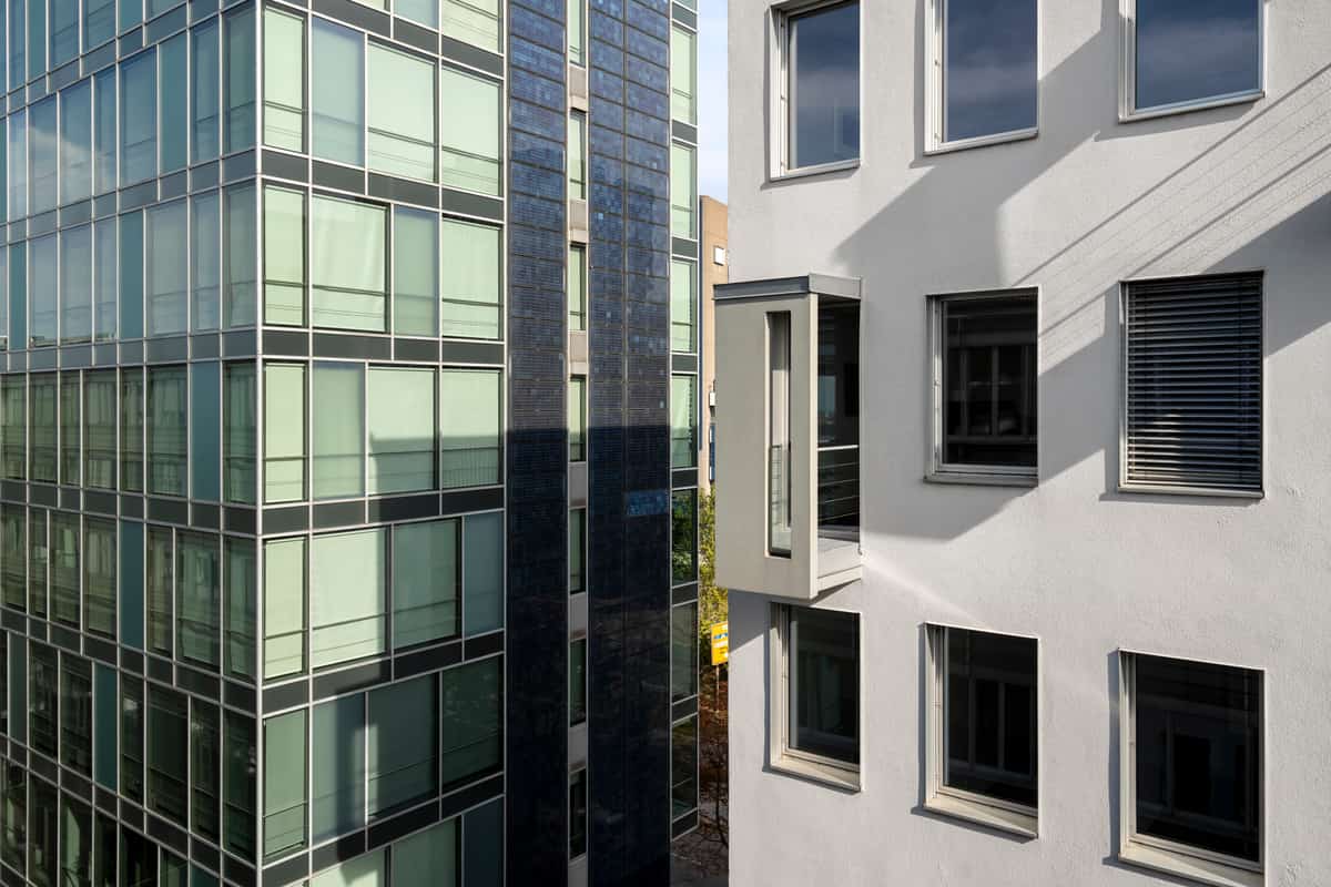 Fassadendetail der Bahnhofszeile mit Glasfassade neben einer gegliederten Nachbarfassade
