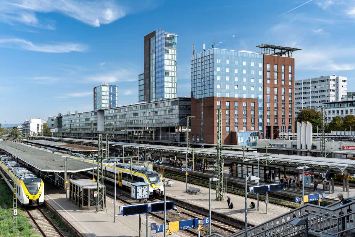 Gebäudezeile am Freiburger Hauptbahnhof mit Gleisfeld und Zügen