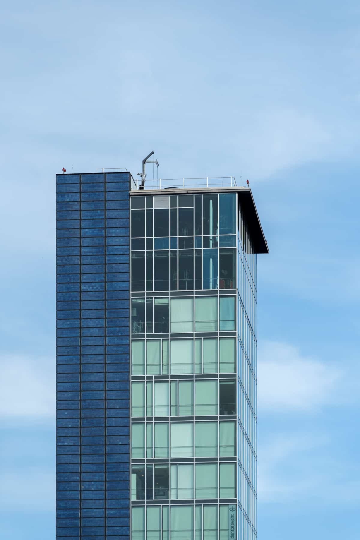 Bürohochhaus der Bahnhofszeile Freiburg mit Glasfassade vor blauem Himmel