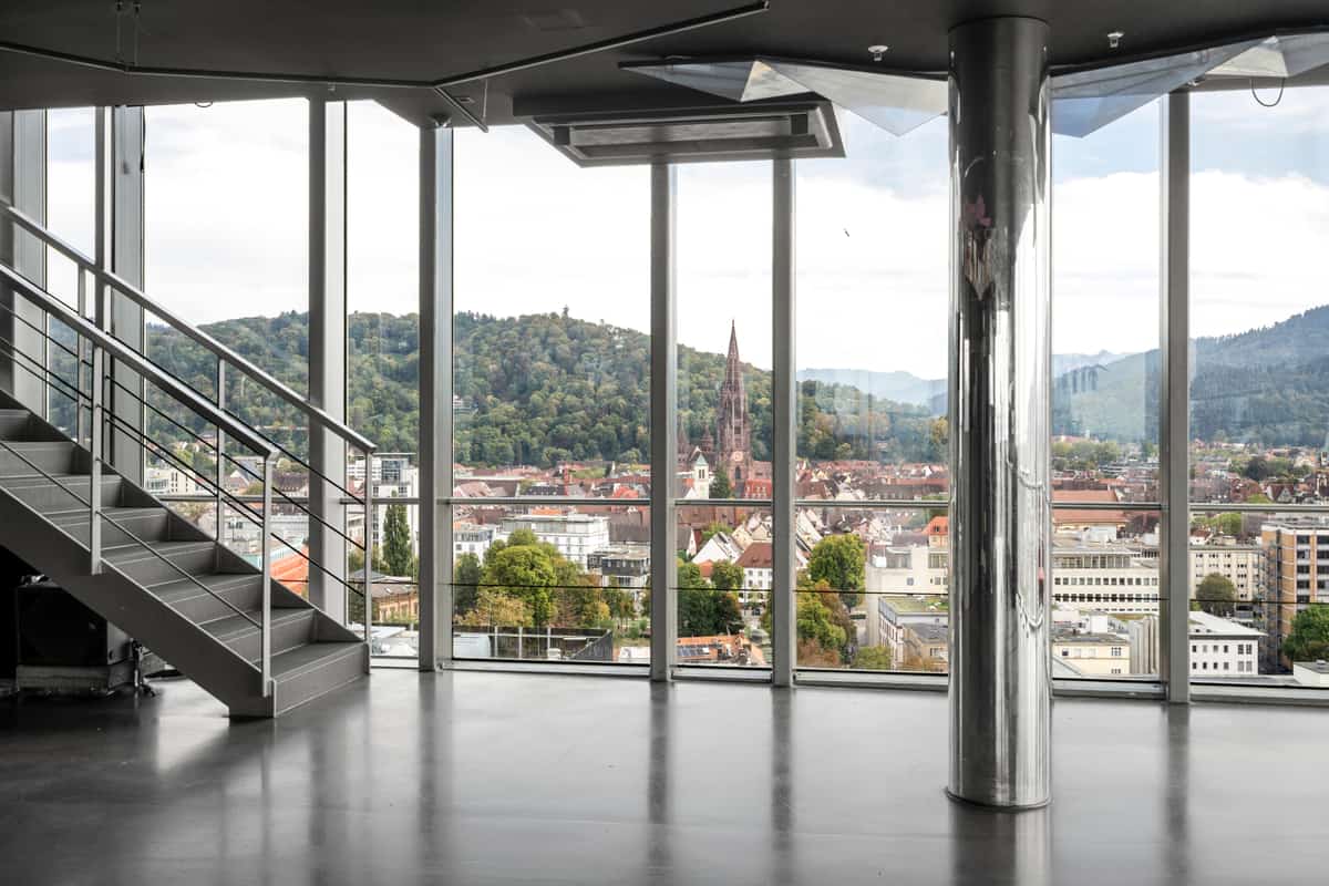 Neko Bar, Rooftop-Bar in der Bahnhofszeile Freiburg, mit Treppe, Glasfront und Blick auf Stadt und Berge