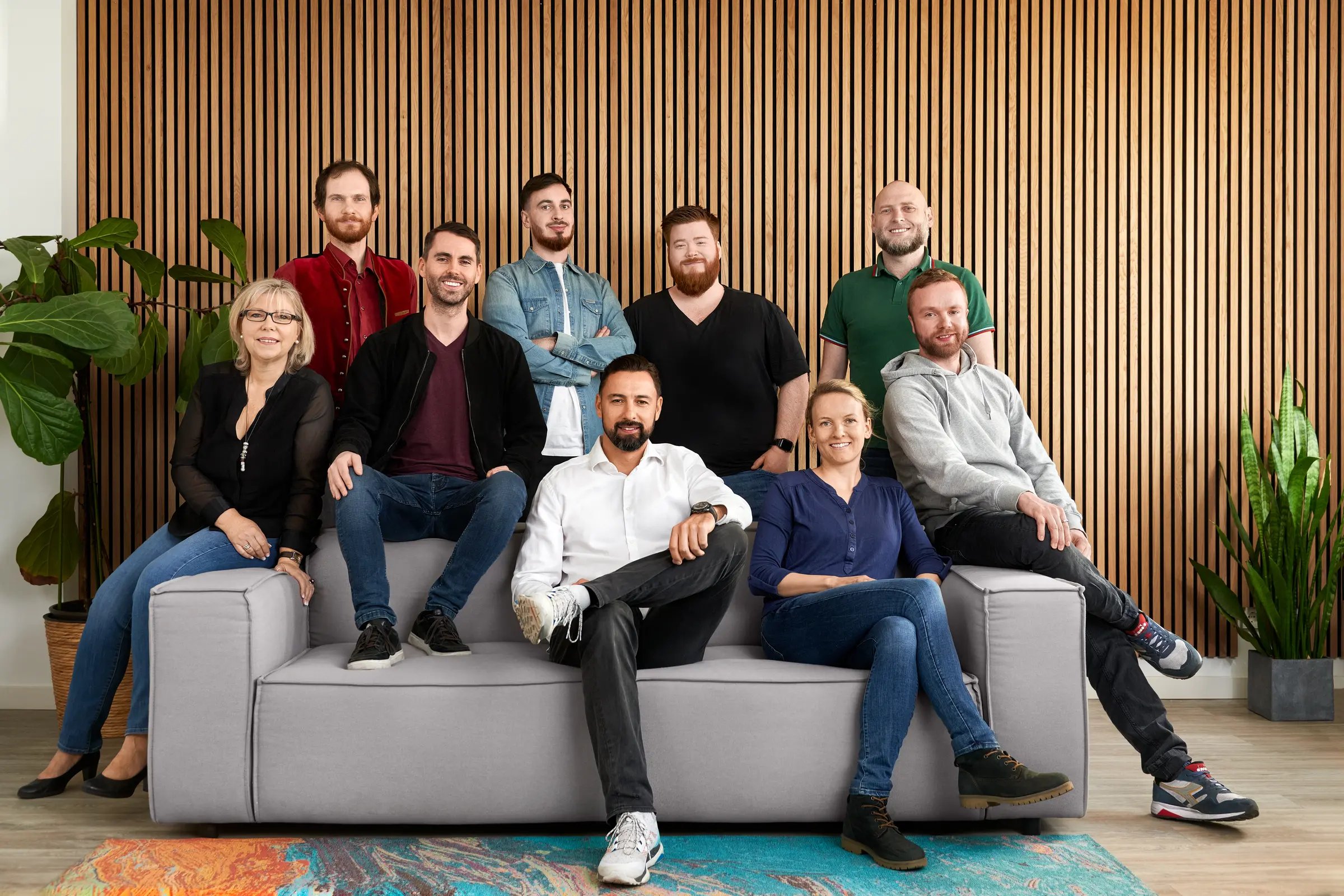 Fotograf Heidelberg · Großes Team-Businessportrait vor Akustikholz-Wand