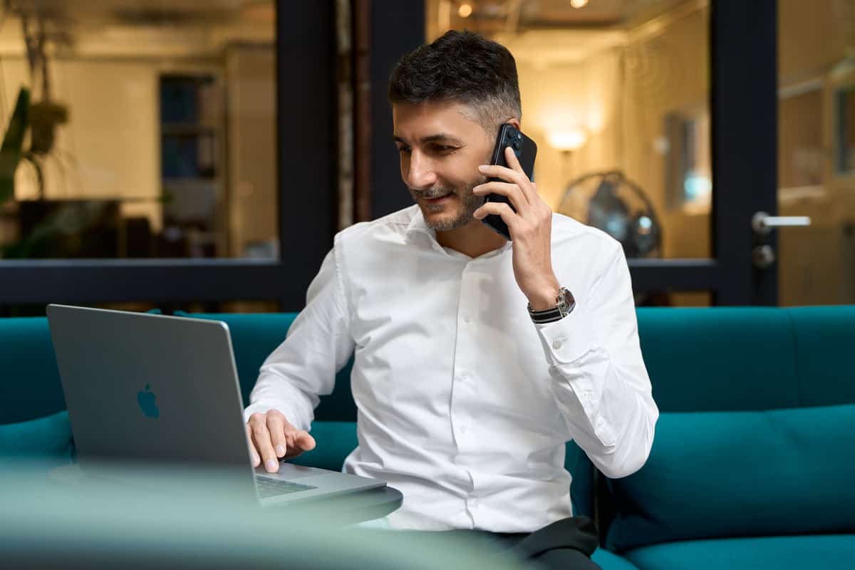 Giuseppe Conforti bei der Arbeit, Laptop und Telefon, industrielles Ambiente der Lokhalle.