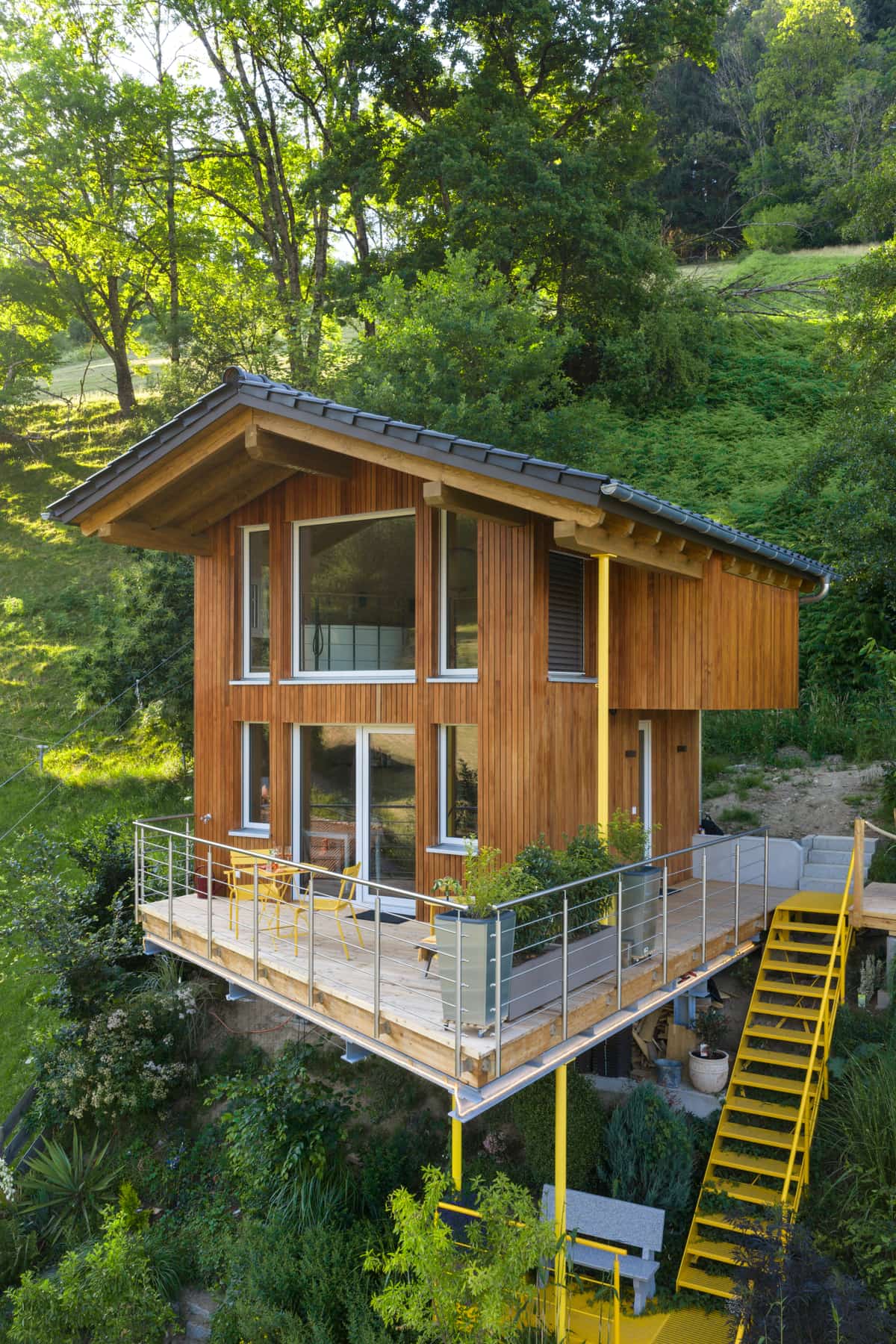 Holzfassade mit Giebel, Balkon und Außentreppe des Ferienhauses, Drohnenaufnahme