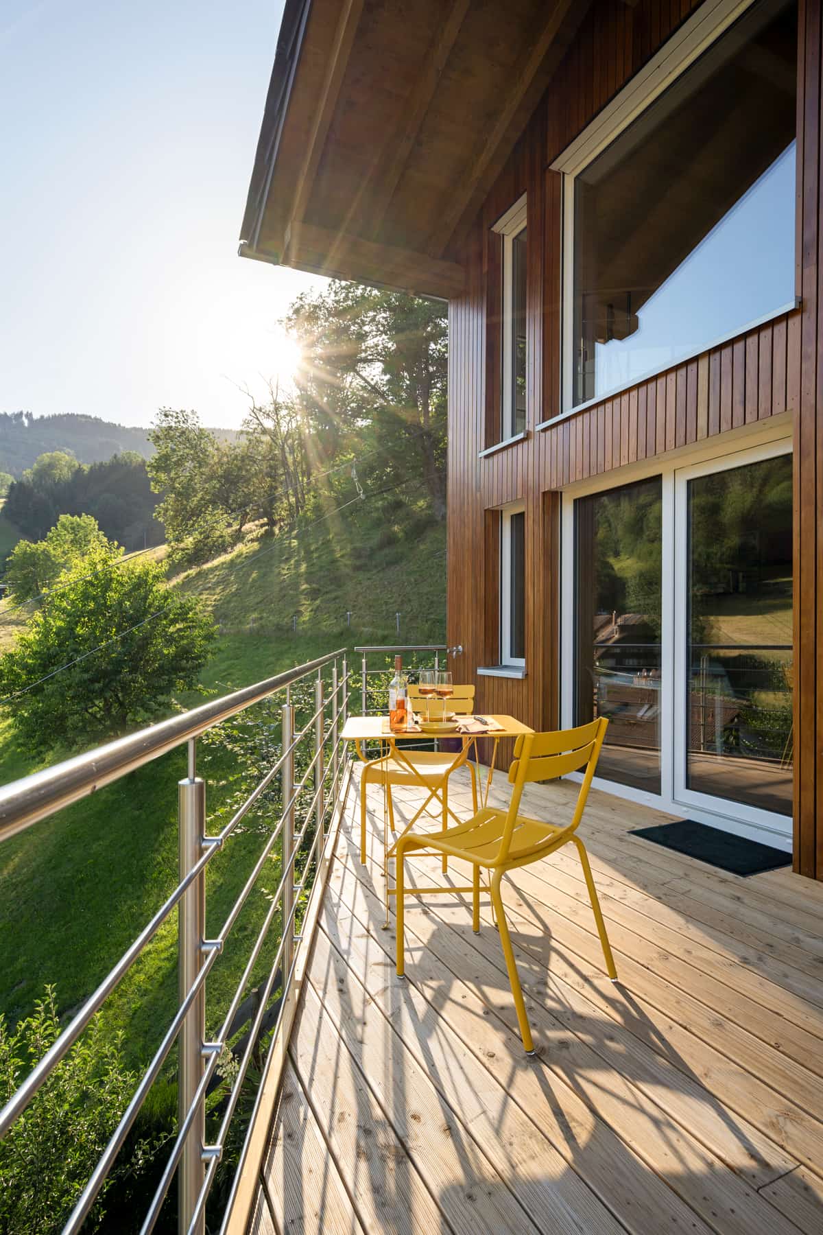 Terrasse im Abendlicht mit Sonnenstern über dem Tal