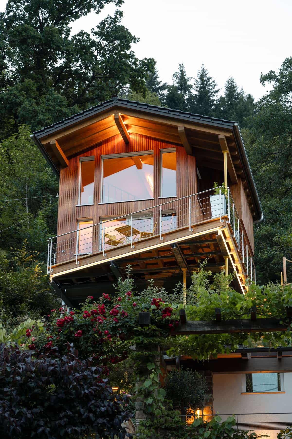 Das beleuchtete Ferienhaus in der Abenddämmerung