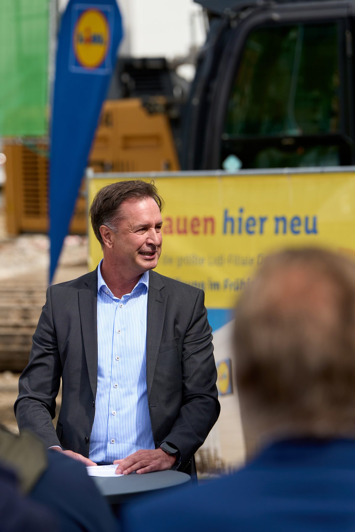 Gruppenbild mit Spaten vor Baugerät und Lidl-Bautafel