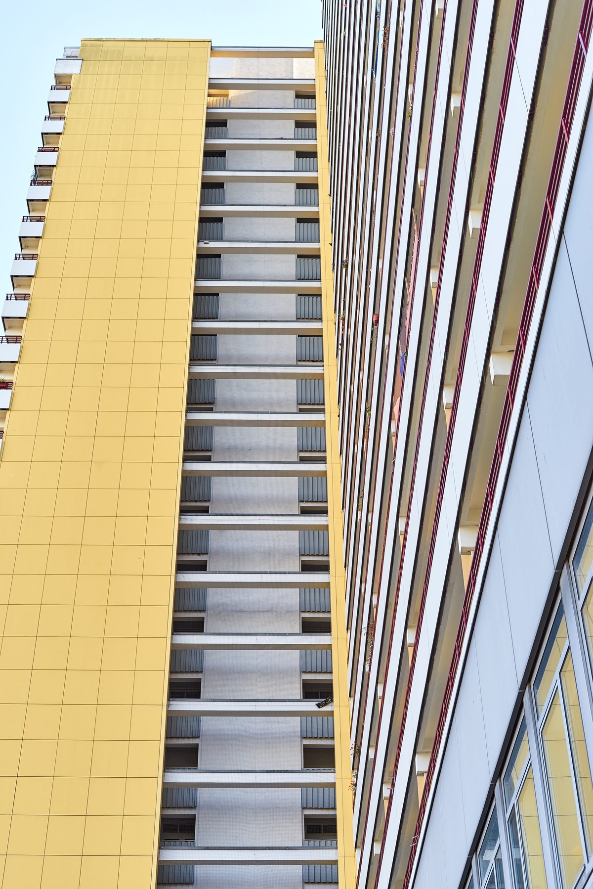 Zwei hohe Wohngebäude in Berlin-Marzahn, eines gelb und eines weiß, mit vielen Balkonen und Fenstern.